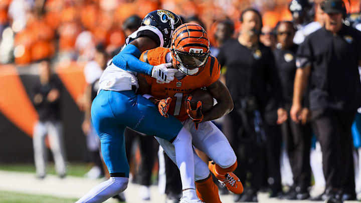 Sep 14, 2025; Cincinnati, Ohio, USA; Cincinnati Bengals wide receiver Ja'Marr Chase (1) runs with the ball against Jacksonville Jaguars defensive back Travis Hunter (12) in the second half at Paycor Stadium. Mandatory Credit: Katie Stratman-Imagn Images