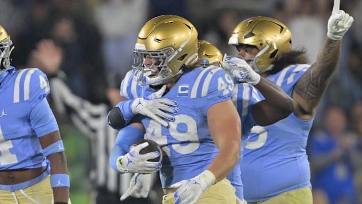 Nov 8, 2024; Pasadena, California, USA;   UCLA Bruins linebacker Carson Schwesinger (49) and teammates celebrate after an interception in the second half against the Iowa Hawkeyes at the Rose Bowl. Mandatory Credit: Jayne Kamin-Oncea-Imagn Images