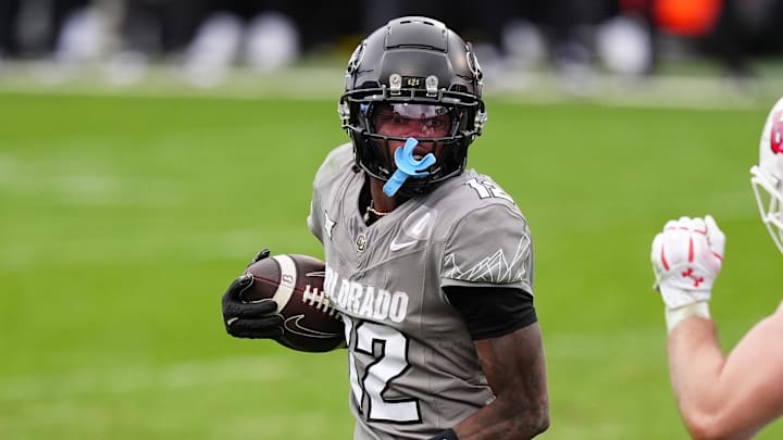 Nov 16, 2024; Boulder, Colorado, USA; Colorado Buffaloes wide receiver Travis Hunter (12) carries the ball for a touchdown in the fourth quarter against the Utah Utes at Folsom Field. Mandatory Credit: Ron Chenoy-Imagn Images