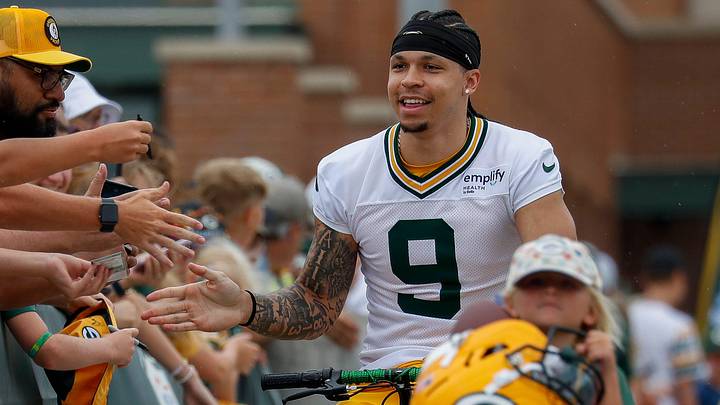 Green Bay Packers receiver Christian Watson slaps hands with fans as he rides a bicycle to practice at training camp last year. Green Bay Packers receiver Christian Watson slaps hands with fans as he rides a bicycle to practice at training camp last year.