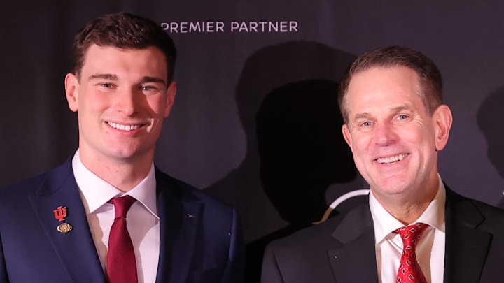 Dec 13, 2025; New York, NY, USA; Indiana Hoosiers quarterback Fernando Mendoza (left) and head coach Curt Cignetti pose for photos with the Heisman trophy during a press conference at the New York Marriott Marquis after Mendoza wins the award. Mandatory Credit: Brad Penner-Imagn Images