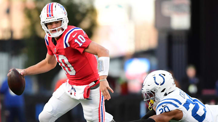 Dec 1, 2024; Foxborough, Massachusetts, USA;  New England Patriots quarterback Drake Maye (10) runs with the ball while Indianapolis Colts safety Nick Cross (20) defends during the second half at Gillette Stadium. Mandatory Credit: Bob DeChiara-Imagn Images