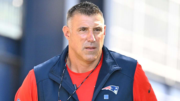 Jul 23, 2025; Foxborough, MA, USA; New England Patriots head coach Mike Vrabel delivers a puppy to a local family as part of the Patriots pet adoption event before the start of training camp at Gillette Stadium. Mandatory Credit: Eric Canha-Imagn Images