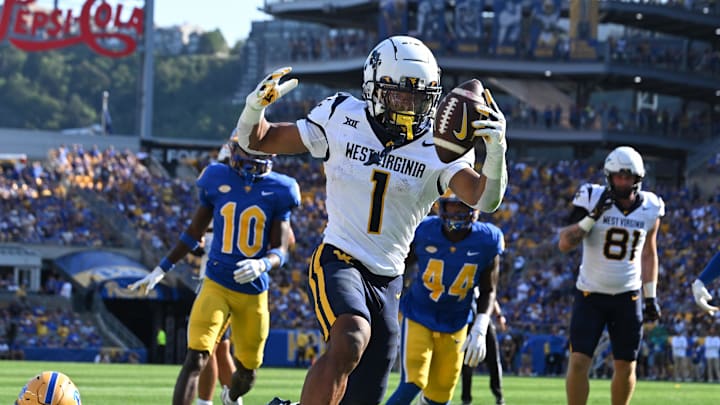 Sep 14, 2024; Pittsburgh, Pennsylvania, USA; West Virginia Mountaineers running back Jahiem White (1) scores a touchdown  against Pittsburgh Panthers defensive back Donovan McMillon (3) during the second quarter at Acrisure Stadium. Mandatory Credit: Barry Reeger-Imagn Images