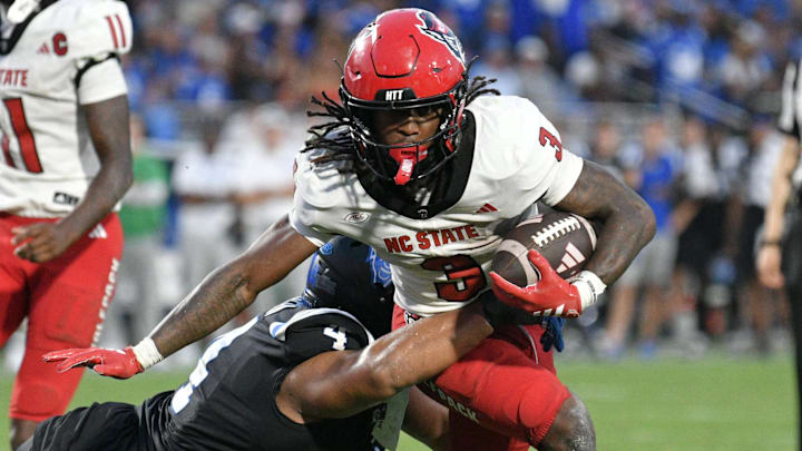 Sep 20, 2025; Durham, North Carolina, USA;  North Carolina State Wolfpack running back Hollywood Smothers (3) is tackled by Duke Blue Devils running back Anderson Castle (4) during the fourth quarter  at Wallace Wade Stadium. Mandatory Credit: Zachary Taft-Imagn Images