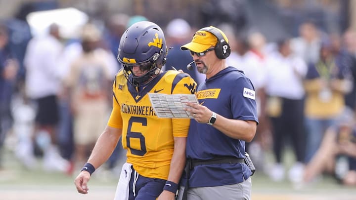 Aug 31, 2024; Morgantown, West Virginia, USA; West Virginia Mountaineers head coach Neal Brown talks with West Virginia Mountaineers quarterback Garrett Greene (6) during the second quarter against the Penn State Nittany Lions at Mountaineer Field at Milan Puskar Stadium. Mandatory Credit: Ben Queen-Imagn Images Aug 31, 2024; Morgantown, West Virginia, USA; West Virginia Mountaineers head coach Neal Brown talks with West Virginia Mountaineers quarterback Garrett Greene (6) during the second quarter against the Penn State Nittany Lions at Mountaineer Field at Milan Puskar Stadium. Mandatory Credit: Ben Queen-Imagn Images
