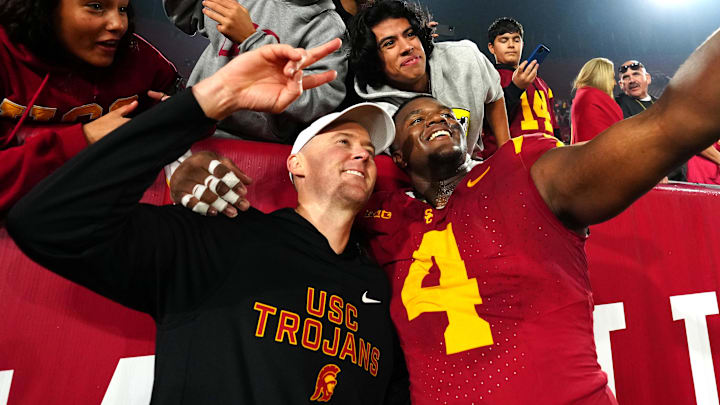 Nov 29, 2025; Los Angeles, California, USA; Southern California Trojans head coach Lincoln Riley (right) and defensive tackle Jahkeem Stewart (4) pose with fans after the game against the UCLA Bruins at United Airlines Field at Los Angeles Memorial Coliseum.