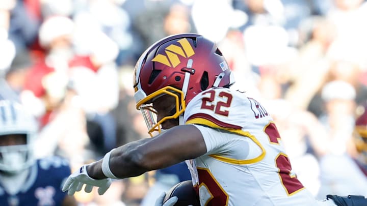 Washington Commanders running back Jacory Croskey-Merritt avoids a tackle by Dallas Cowboys defensive end Sam Williams.