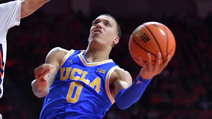 Feb 11, 2025; Champaign, Illinois, USA;  UCLA Bruins guard Kobe Johnson (0) drives to the basket as Illinois Fighting Illini forward Will Riley (7) defends during the second half at State Farm Center. Mandatory Credit: Ron Johnson-Imagn Images