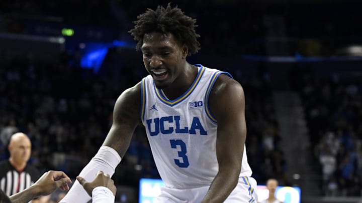 Jan 30, 2025; Los Angeles, California, USA;  UCLA Bruins guard Eric Dailey Jr. (3) celebrates as he helps up guard Sebastian Mack (12) after making a defensive play against the Oregon Ducks during the second half at Pauley Pavilion presented by Wescom. Mandatory Credit: Alex Gallardo-Imagn Images