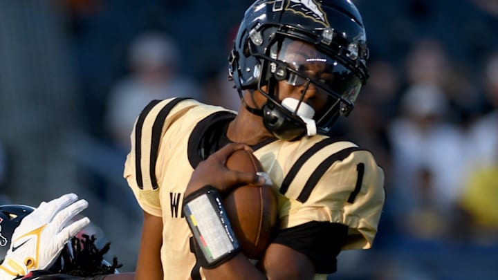 Warren Harding quarterback Chaz Coleman spins for a gain in the first quarter at Canton McKinley football at Tom Benson Hall of Fame Stadium. Thursday, August 22, 2024. Warren Harding quarterback Chaz Coleman spins for a gain in the first quarter at Canton McKinley football at Tom Benson Hall of Fame Stadium. Thursday, August 22, 2024.