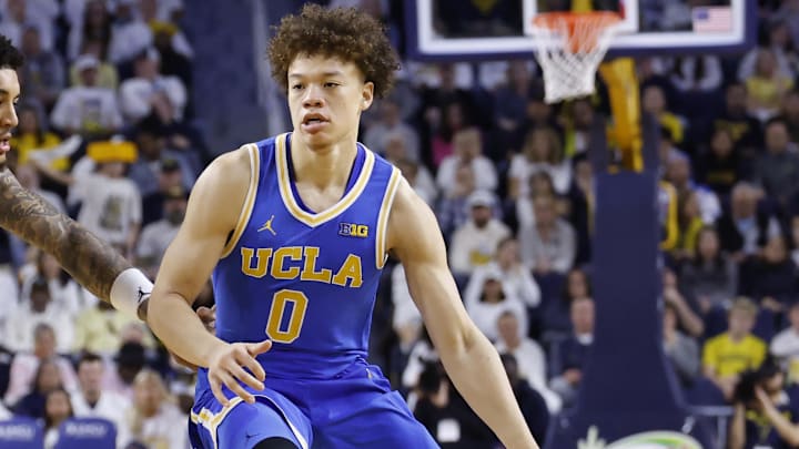 Feb 14, 2026; Ann Arbor, Michigan, USA; UCLA Bruins guard Trent Perry (0) dribbles defended by Michigan Wolverines forward Yaxel Lendeborg (23) in the second half at Crisler Center. Mandatory Credit: Rick Osentoski-Imagn Images