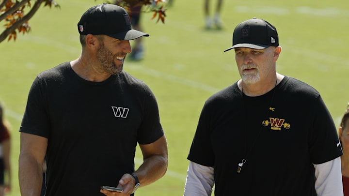 Jul 24, 2025; Ashburn, VA, USA; Washington Commanders general manager Adam Peters (L) talks with Commanders head coach Dan Quinn (R) while walking off the practice field on day two of training camp at OrthoVirginia Training Center at Commanders Park. Mandatory Credit: Geoff Burke-Imagn Images