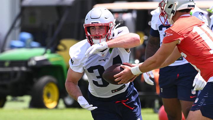 Jun 2, 2026; Foxborough, MA, USA; New England Patriots quarterback Tommy DeVito (16) hands the ball off to running back Lan Larison (34) during the team's OTA at Gillette Stadium. Mandatory Credit: Eric Canha-Imagn Images Jun 2, 2026; Foxborough, MA, USA; New England Patriots quarterback Tommy DeVito (16) hands the ball off to running back Lan Larison (34) during the team's OTA at Gillette Stadium. Mandatory Credit: Eric Canha-Imagn Images