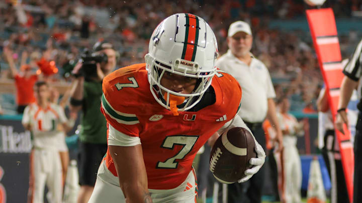 Sep 6, 2025; Miami Gardens, Florida, USA; Miami Hurricanes wide receiver CJ Daniels (7) scores a touchdown against Bethune-Cookman Wildcats cornerback Gabe White (17) during the second quarter at Hard Rock Stadium. Mandatory Credit: Sam Navarro-Imagn Images