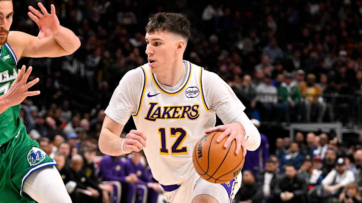 Jan 24, 2026; Dallas, Texas, USA; Los Angeles Lakers forward Jake LaRavia (12) moves the ball past Dallas Mavericks forward Dwight Powell (7) during the game at the American Airlines Center. Mandatory Credit: Jerome Miron-Imagn Images
