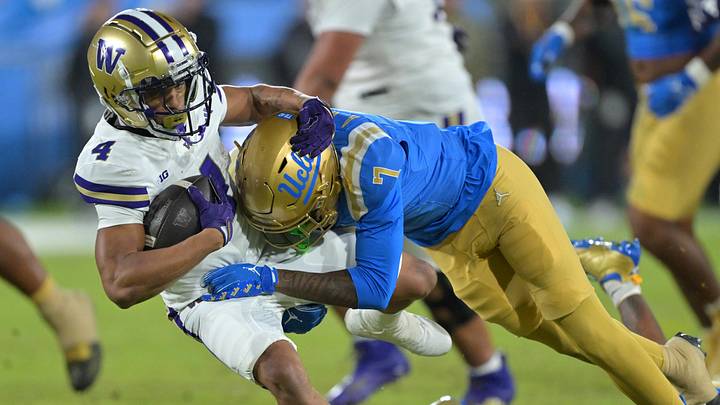 Nov 22, 2025; Pasadena, California, USA; Washington Huskies running back Jordan Washington (4) is stopped by UCLA Bruins defensive back Aaron Williams (7) after a gain of 17 yards and a first down during the second half at the Rose Bowl. Mandatory Credit: Jayne Kamin-Oncea-Imagn Images Nov 22, 2025; Pasadena, California, USA; Washington Huskies running back Jordan Washington (4) is stopped by UCLA Bruins defensive back Aaron Williams (7) after a gain of 17 yards and a first down during the second half at the Rose Bowl. Mandatory Credit: Jayne Kamin-Oncea-Imagn Images