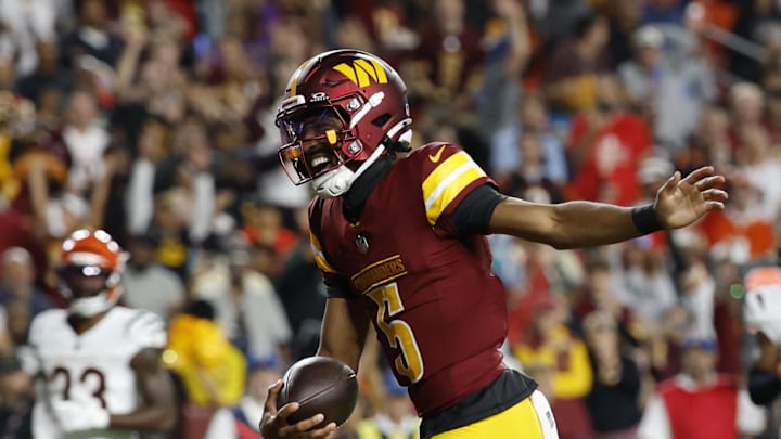 Washington Commanders quarterback Jayden Daniels celebrates after scoring a touchdown.