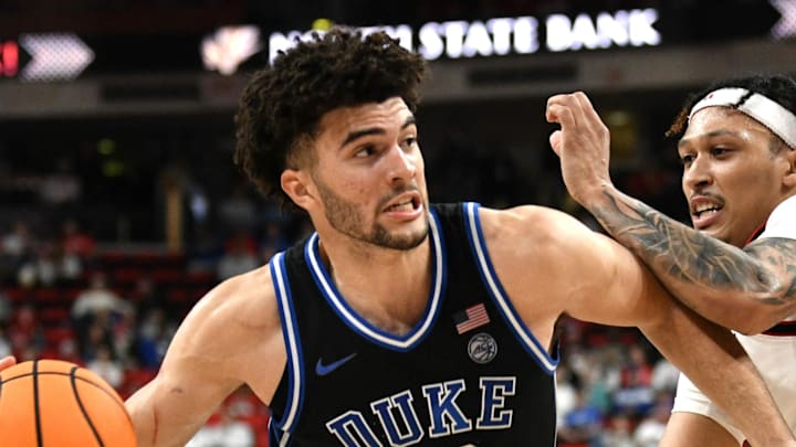 Mar 2, 2026; Raleigh, North Carolina, USA;  Duke Blue Devils forward Cameron Boozer (12) drives the ball around NC State Wolfpack forward Darrion Williams (1) during the first half at Lenovo Center. Mandatory Credit: Zachary Taft-Imagn Images