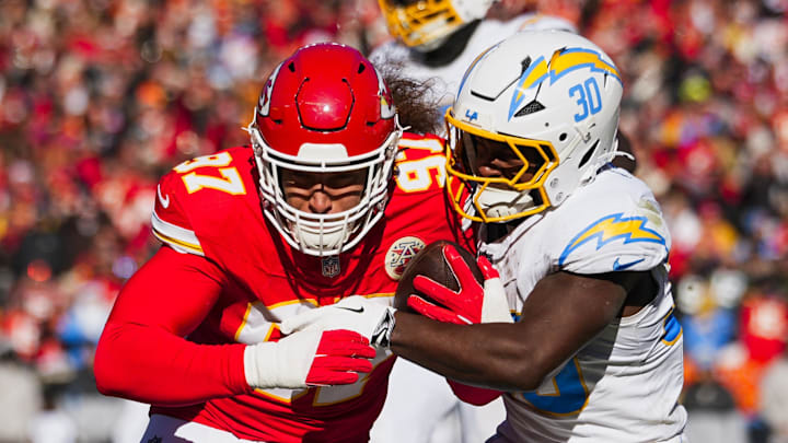 Dec 14, 2025; Kansas City, Missouri, USA; Kansas City Chiefs defensive end Ashton Gillotte (97) is tackled by Los Angeles Chargers running back Kimani Vidal (30) following an interception during the second quarter at GEHA Field at Arrowhead Stadium. Mandatory Credit: Jay Biggerstaff-Imagn Images | Jay Biggerstaff-Imagn Images
