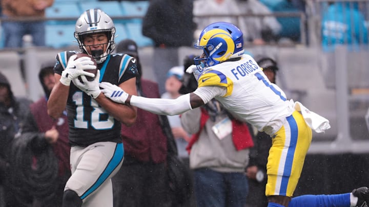 Nov 30, 2025; Charlotte, North Carolina, USA;  Carolina Panthers wide receiver Jalen Coker (18) makes a catch as Los Angeles Rams cornerback Emmanuel Forbes Jr. (1) defends during the third quarter at Bank of America Stadium. Mandatory Credit: Scott Kinser-Imagn Images