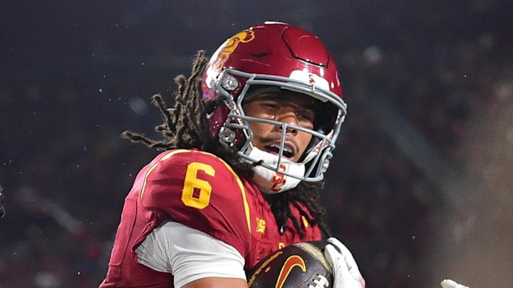 Nov 7, 2025; Los Angeles, California, USA; Southern California Trojans wide receiver Makai Lemon (6) scores a touchdown against Northwestern Wildcats defensive back Josh Fussell (13) during the first half at the Los Angeles Memorial Coliseum. Mandatory Credit: Gary A. Vasquez-Imagn Images