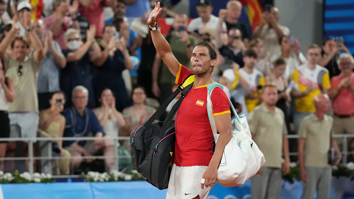Rafael Nadal waves to the crowd at the 2024 Paris Olympics after losing a match.