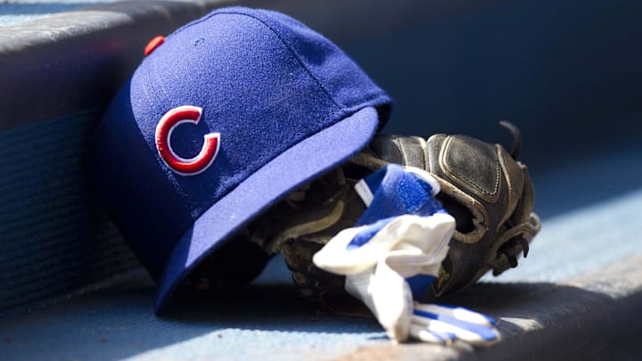 Chicago Cubs hat and glove in the dugout
