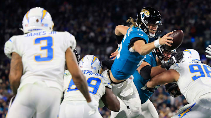 Jacksonville Jaguars quarterback Trevor Lawrence (16) scores a two point conversion between Los Angeles Chargers defensive tackle Sebastian Joseph-Day (69) and defensive tackle Breiden Fehoko (96) during the fourth quarter of an NFL first round playoff football matchup Saturday, Jan. 14, 2023 at TIAA Bank Field in Jacksonville, Fla. The Jacksonville Jaguars edged the Los Angeles Chargers on a field goal 31-30. Jacksonville Jaguars quarterback Trevor Lawrence (16) scores a two point conversion between Los Angeles Chargers defensive tackle Sebastian Joseph-Day (69) and defensive tackle Breiden Fehoko (96) during the fourth quarter of an NFL first round playoff football matchup Saturday, Jan. 14, 2023 at TIAA Bank Field in Jacksonville, Fla. The Jacksonville Jaguars edged the Los Angeles Chargers on a field goal 31-30.