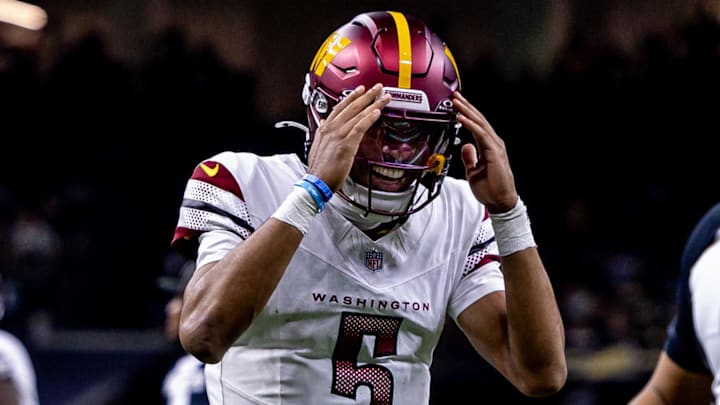 Dec 15, 2024; New Orleans, Louisiana, USA;  Washington Commanders quarterback Jayden Daniels (5) reacts to throwing a touchdown to wide receiver Terry McLaurin (17) against the New Orleans Saints during the first half at Caesars Superdome. Mandatory Credit: Stephen Lew-Imagn Images
