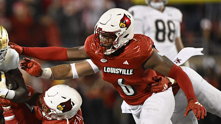 Oct 7, 2023; Louisville, Kentucky, USA; Louisville Cardinals defensive back Devin Neal (27) and Louisville Cardinals linebacker Stanquan Clark (6) tackle Notre Dame Fighting Irish running back Jeremiyah Love (12) during the second half at L&N Federal Credit Union Stadium. Louisville defeated Notre Dame 33-20. Mandatory Credit: Jamie Rhodes-Imagn Images