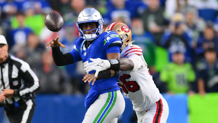 Oct 10, 2024; Seattle, Washington, USA; Seattle Seahawks quarterback Geno Smith (7) passes the ball while defended by San Francisco 49ers defensive end Leonard Floyd (56) during the first half at Lumen Field. Mandatory Credit: Steven Bisig-Imagn Images