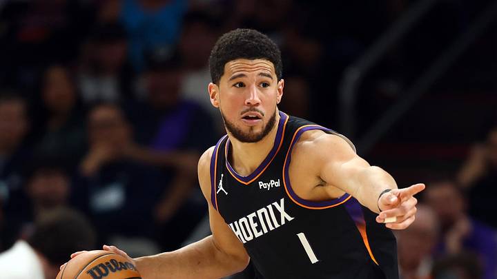 Apr 17, 2026; Phoenix, Arizona, USA; Phoenix Suns guard Devin Booker (1) against the Golden State Warriors during the first half in the play-in rounds of the 2026 NBA Playoffs at Mortgage Matchup Center. Mandatory Credit: Mark J. Rebilas-Imagn Images