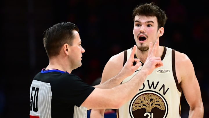 Dec 6, 2025; Cleveland, Ohio, USA; Golden State Warriors center Quinten Post (21) reacts to a foul called by referee Gediminas Petraitis (50) during the second half against the Cleveland Cavaliers at Rocket Arena. Mandatory Credit: Ken Blaze-Imagn Images