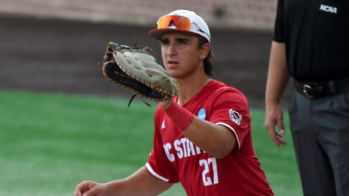 Stetson Hatters' Isaiah Barkett (13) drives back safely to first as NC State Wolfpack's Chris McHugh (27) waits on the pickoff attempt during the NCAA Baseball Regional Tournament at Plainsman Park in Auburn, Ala., on Friday May 30, 2025.