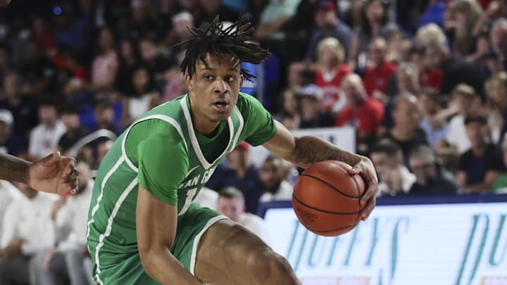 Jan 28, 2024; Boca Raton, Florida, USA; North Texas Mean Green forward Aaron Scott (1) dribbles the basket as Florida Atlantic Owls guard Johnell Davis (1) defends during the first half at Eleanor R. Baldwin Arena. Mandatory Credit: Sam Navarro-Imagn Images