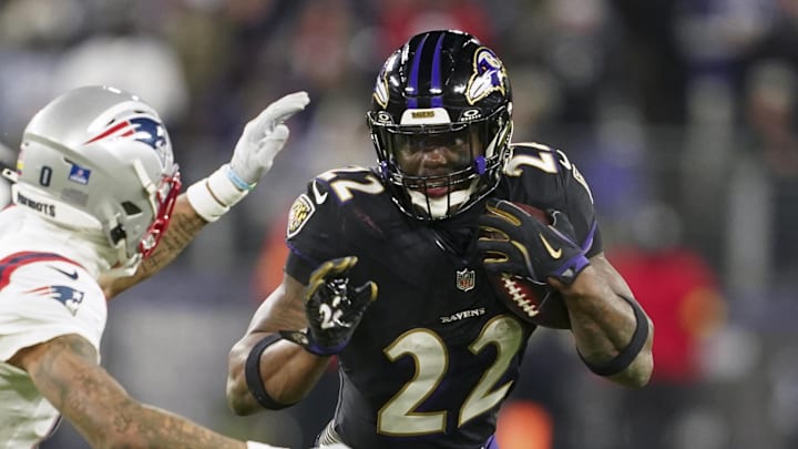 Dec 21, 2025; Baltimore, Maryland, USA;  Baltimore Ravens running back Derrick Henry (22) runs the ball against New England Patriots cornerback Christian Gonzalez (0) during the second half of the game at M&T Bank Stadium. Mandatory Credit: Mitch Stringer-Imagn Images