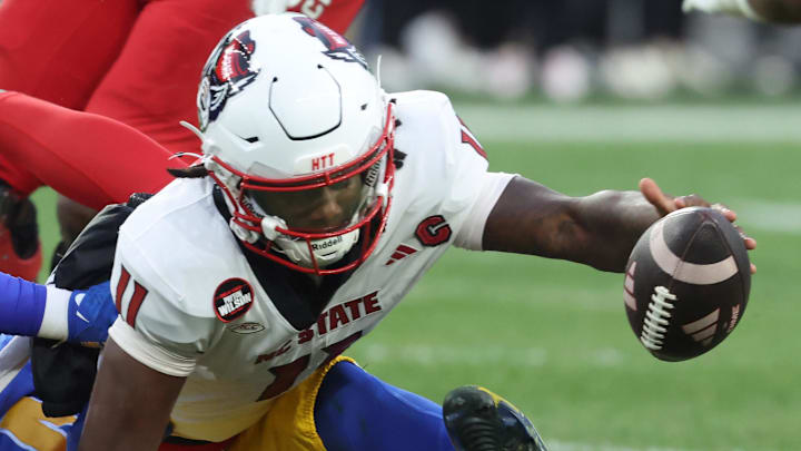Oct 25, 2025; Pittsburgh, Pennsylvania, USA; North Carolina State Wolfpack quarterback CJ Bailey (11) reaches for his fumble against the Pittsburgh Panthers during the third quarter at Acrisure Stadium. Mandatory Credit: Charles LeClaire-Imagn Images Oct 25, 2025; Pittsburgh, Pennsylvania, USA; North Carolina State Wolfpack quarterback CJ Bailey (11) reaches for his fumble against the Pittsburgh Panthers during the third quarter at Acrisure Stadium. Mandatory Credit: Charles LeClaire-Imagn Images