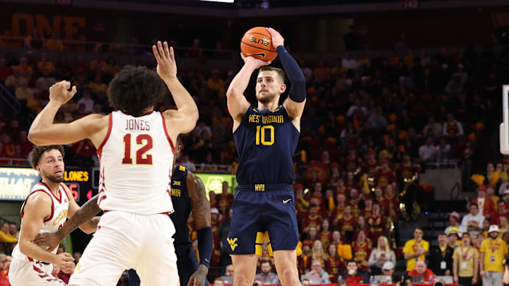 Feb 27, 2023; Ames, Iowa, USA; West Virginia Mountaineers guard Erik Stevenson (10) shoots over the defense from Iowa State Cyclones forward Robert Jones (12) during the first half at James H. Hilton Coliseum. 