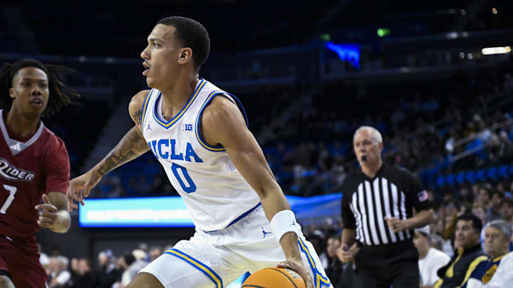 Nov 4, 2024; Los Angeles, California, USA; UCLA Bruins guard Kobe Johnson (0) drives the baseline past Rider Broncs forward Ife West-Ingram (7) during the first half at Pauley Pavilion presented by Wescom. Mandatory Credit: Robert Hanashiro-Imagn Images