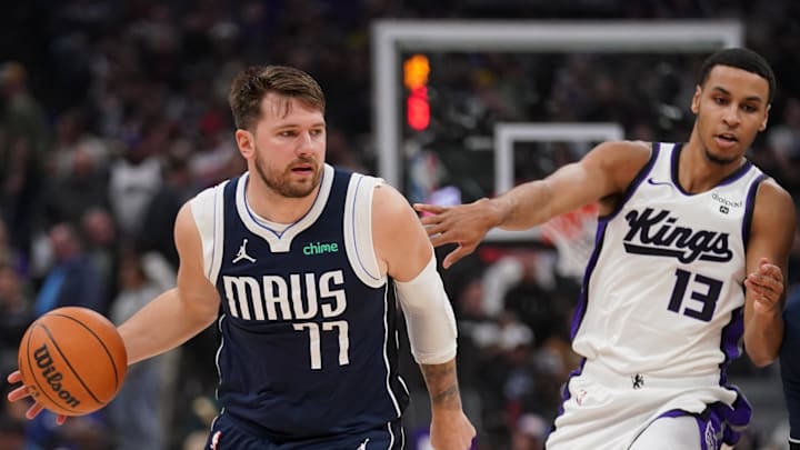 Mar 29, 2024; Sacramento, California, USA; Dallas Mavericks guard Luka Doncic (77) dribbles past Sacramento Kings forward Keegan Murray (13) in the first quarter at the Golden 1 Center. Mandatory Credit: Cary Edmondson-Imagn Images