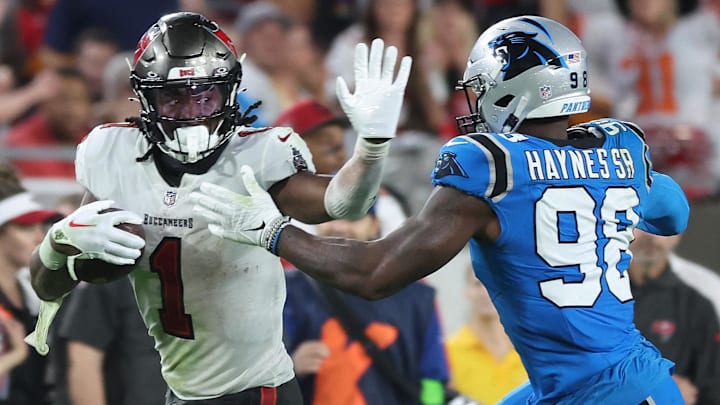 Dec 3, 2023; Tampa, Florida, USA; Tampa Bay Buccaneers running back Rachaad White (1) stiff arms Carolina Panthers linebacker Marquis Haynes Sr. (98)  during the second half at Raymond James Stadium. Mandatory Credit: Kim Klement Neitzel-Imagn Images