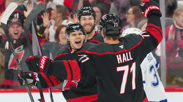 Feb 26, 2026; Raleigh, North Carolina, USA; Carolina Hurricanes center Logan Stankoven (22) is congratulated by defenseman Jaccob Slavin (74) and left wing Taylor Hall (71) for his goal against the Tampa Bay Lightning during the first period at Lenovo Center. Mandatory Credit: James Guillory-Imagn Images Feb 26, 2026; Raleigh, North Carolina, USA; Carolina Hurricanes center Logan Stankoven (22) is congratulated by defenseman Jaccob Slavin (74) and left wing Taylor Hall (71) for his goal against the Tampa Bay Lightning during the first period at Lenovo Center. Mandatory Credit: James Guillory-Imagn Images