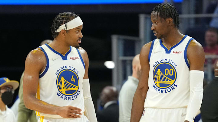 Mar 8, 2022; San Francisco, California, USA; Golden State Warriors guard Moses Moody (4) and forward Jonathan Kuminga (00) talk during the second quarter against the LA Clippers at Chase Center. Mandatory Credit: Darren Yamashita-Imagn Images