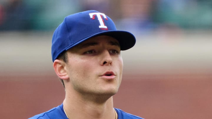 Texas Rangers starting pitcher Jack Leiter (35) rubs up a new baseball