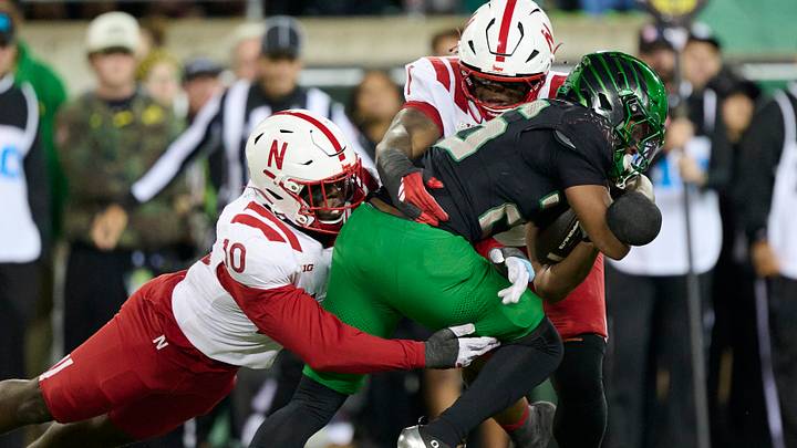 Nebraska's Vincent Shavers Jr. (10) helps take down Oregon running back Brandon Smith.