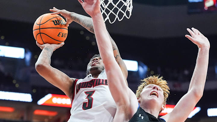 Louisville Cardinals guard Koren Johnson (3) gets two plus the foul against Spalding University's Levi Langley (21) in the second half in the Cards' second exhibition game against Spalding University at the KFC Yum! Center in Louisville, Kentucky Monday, Oct. 28, 2024.