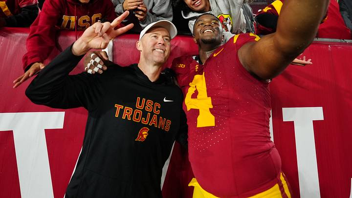 Nov 29, 2025; Los Angeles, California, USA; Southern California Trojans head coach Lincoln Riley (right) and defensive tackle Jahkeem Stewart (4) pose with fans after the game against the UCLA Bruins at United Airlines Field at Los Angeles Memorial Coliseum. Mandatory Credit: Kirby Lee-Imagn Images