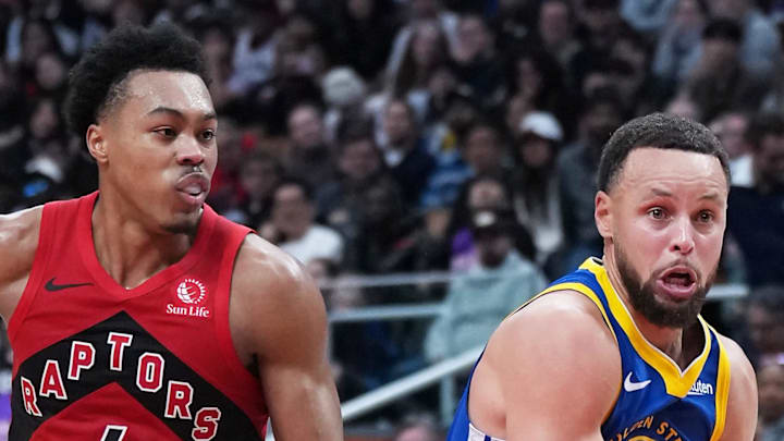 Golden State Warriors guard Stephen Curry controls the ball as Toronto Raptors forward Scottie Barnes tries to defend.