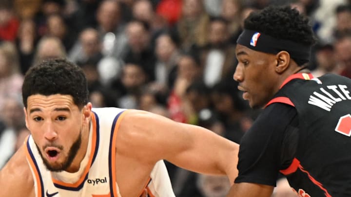 Phoenix Suns guard Devin Booker dribbles the ball around Toronto Raptors guard Ja'Kobe Walter. Phoenix Suns guard Devin Booker dribbles the ball around Toronto Raptors guard Ja'Kobe Walter.